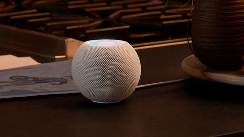 HomePod mini blanc sur un plan de travail près d’une plante